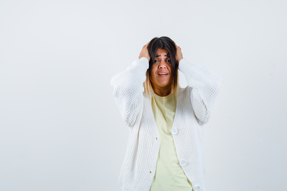 woman dressed in white showing anxiety